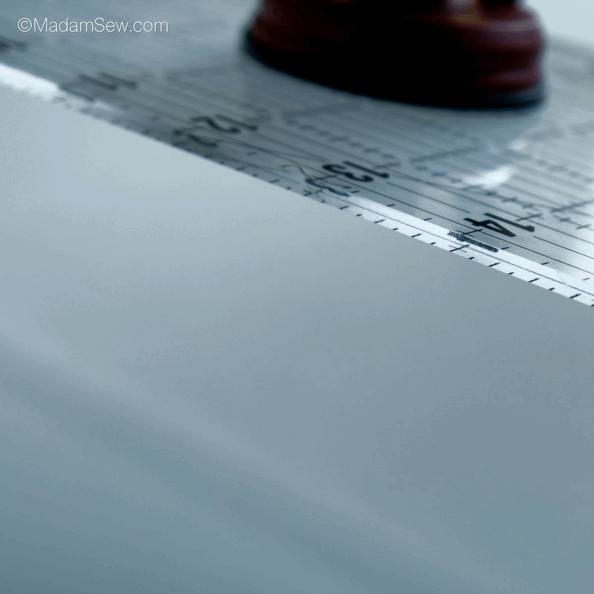 this gif shows how to attach the ruler grip handle to a quilt ruler and pick the ruler up by the handle