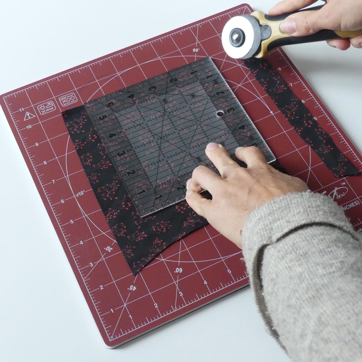 Cutting a piece of fabric on the Madam Sew 12-inch rotating cutting mat