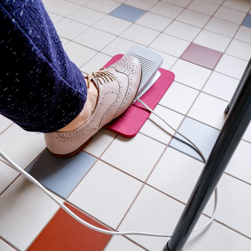 MadamSew Sewing Machine Pedal Mat being used on a tile floor.