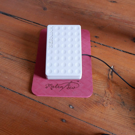 Sewing machine pedal sitting on the MadamSew Sewing Machine Pedal Mat
