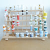 sewing thread rack with spools in different colors and spool huggers and bobbin clamps around the spools