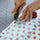 hands cut fabric with a rotary cutter and a ruler