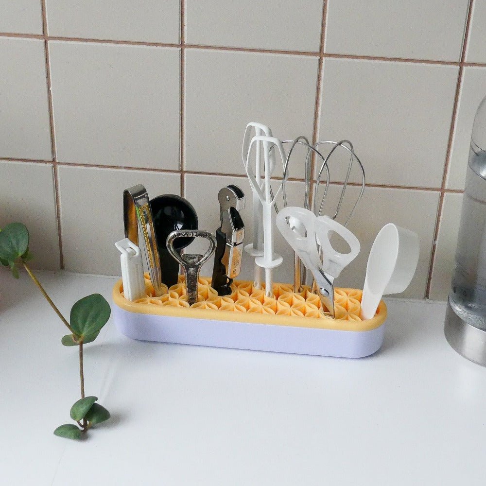 a pen holder that holds small kitchen tools on a counter